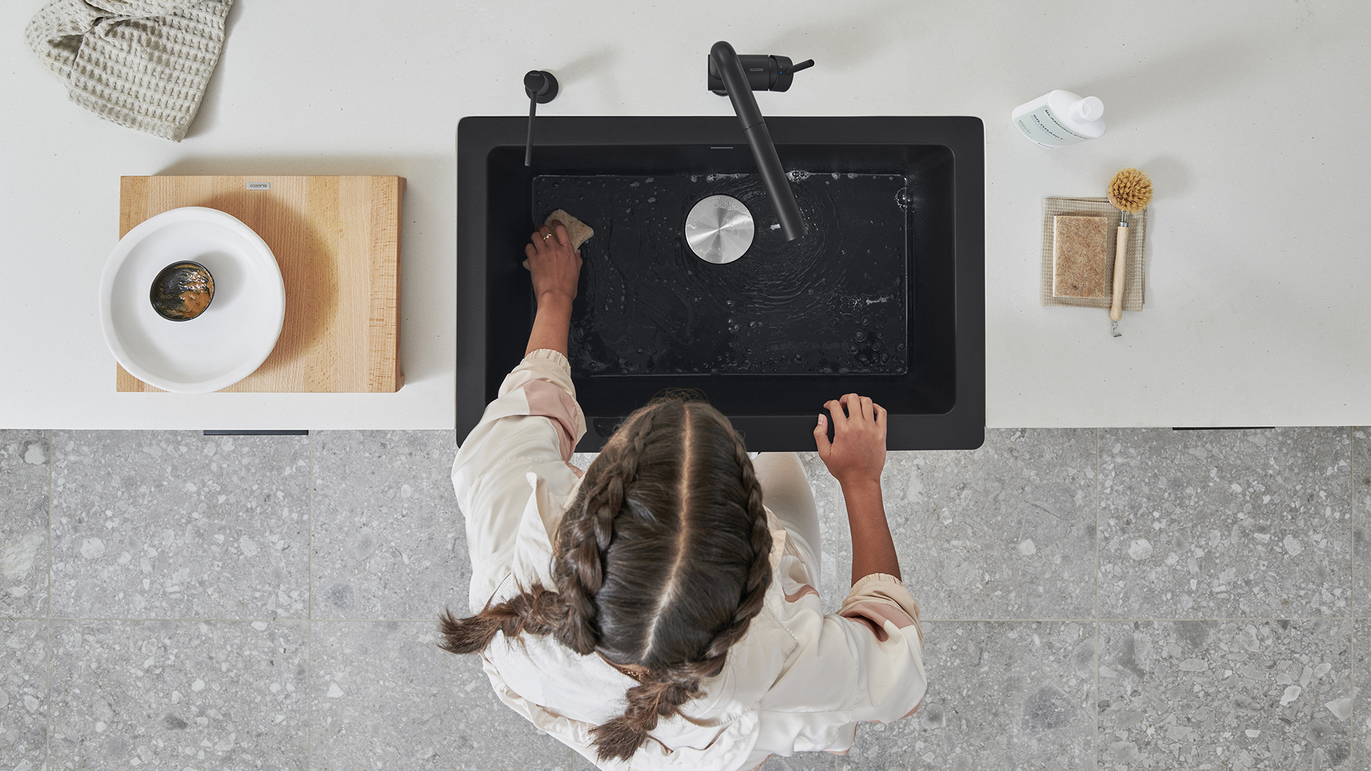 How to clean a SILGRANIT sink - step 1: wet & squeeze some dish soap onto the soft side of a sponge.