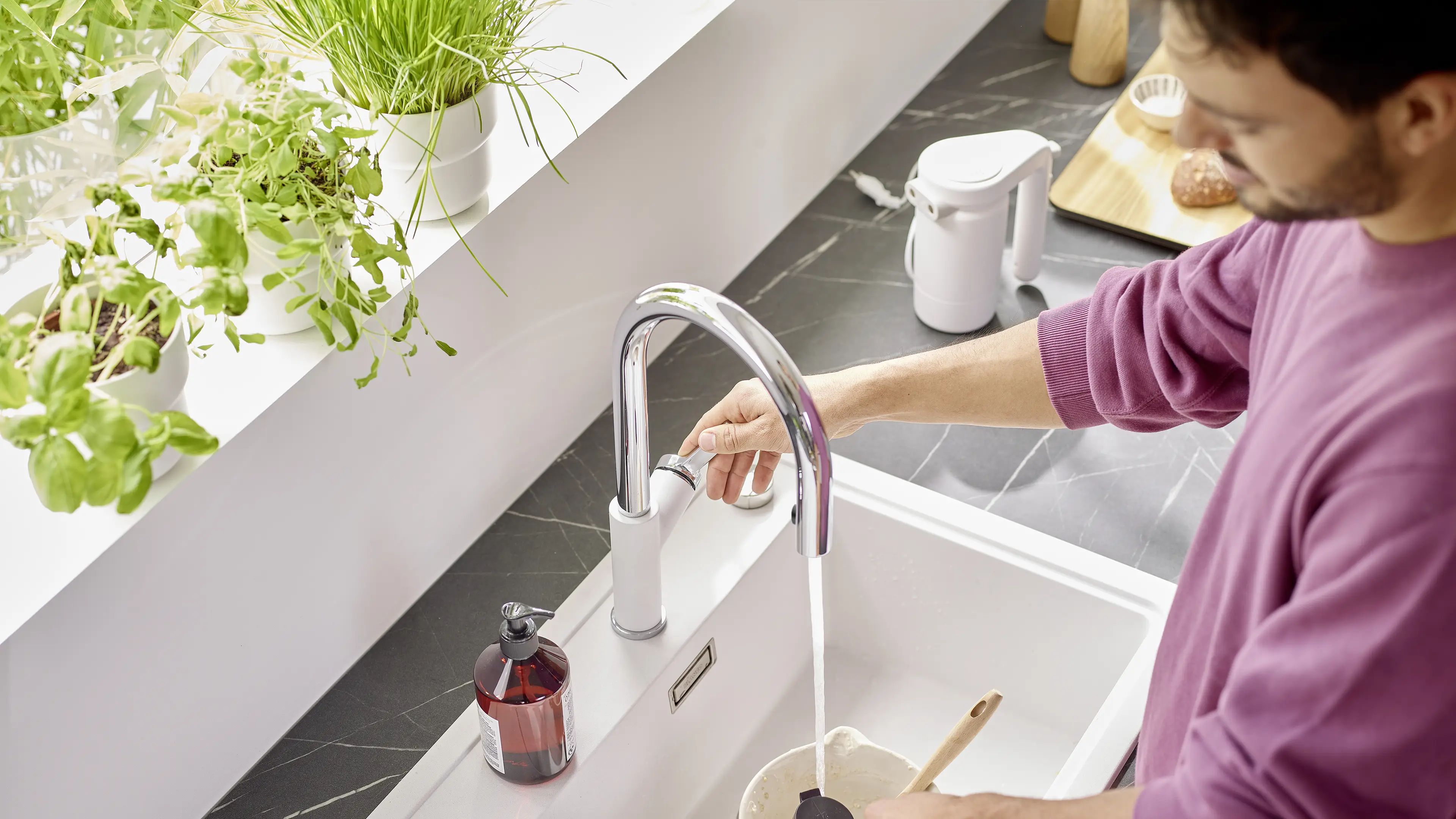 Kitche situation with young man using his mixer tap