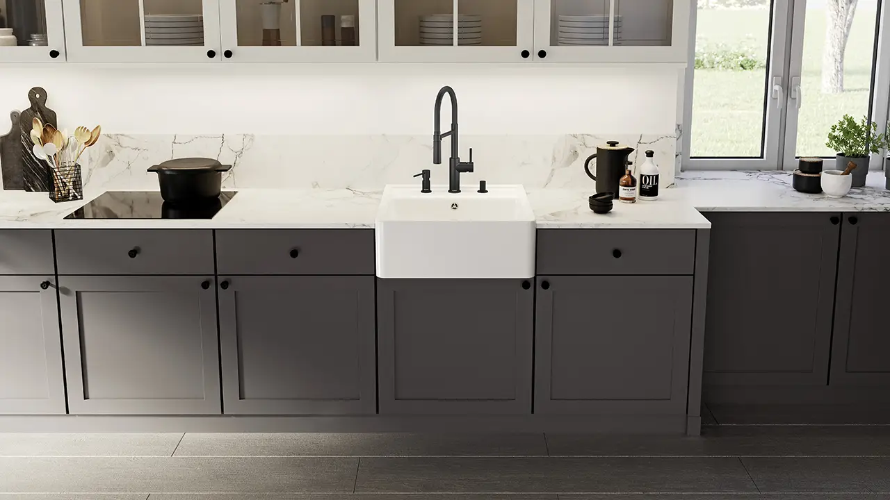 The apron front of a traditional farmhouse-style sink protrudes from the kitchen units.