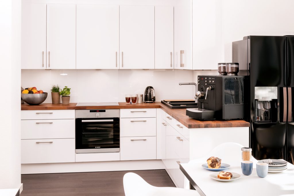 A beautiful office kitchen in white with a wooden worktop
