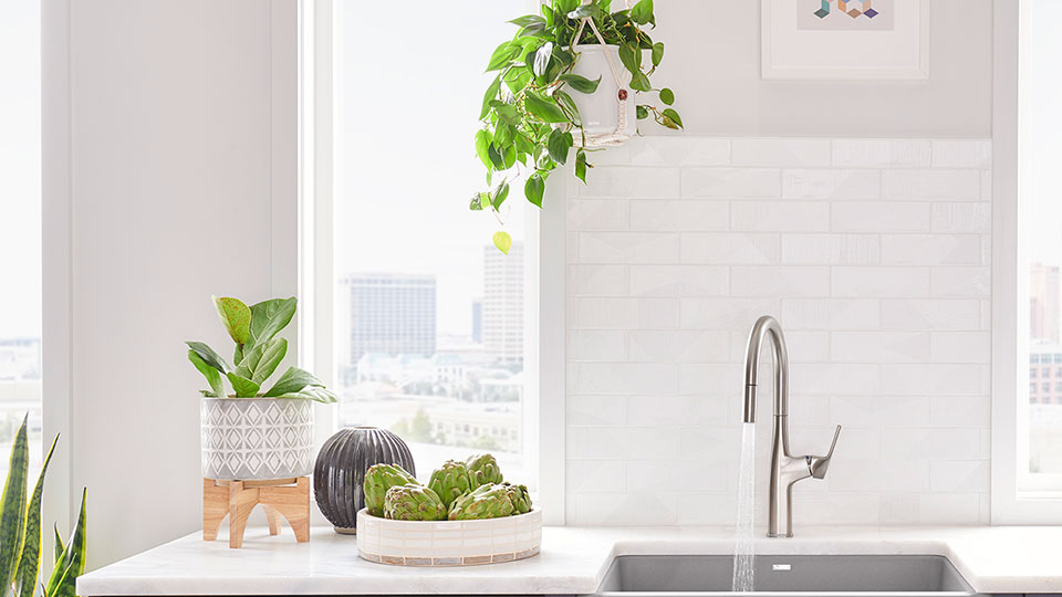 A child repotting a plant on a white Silgranit sink