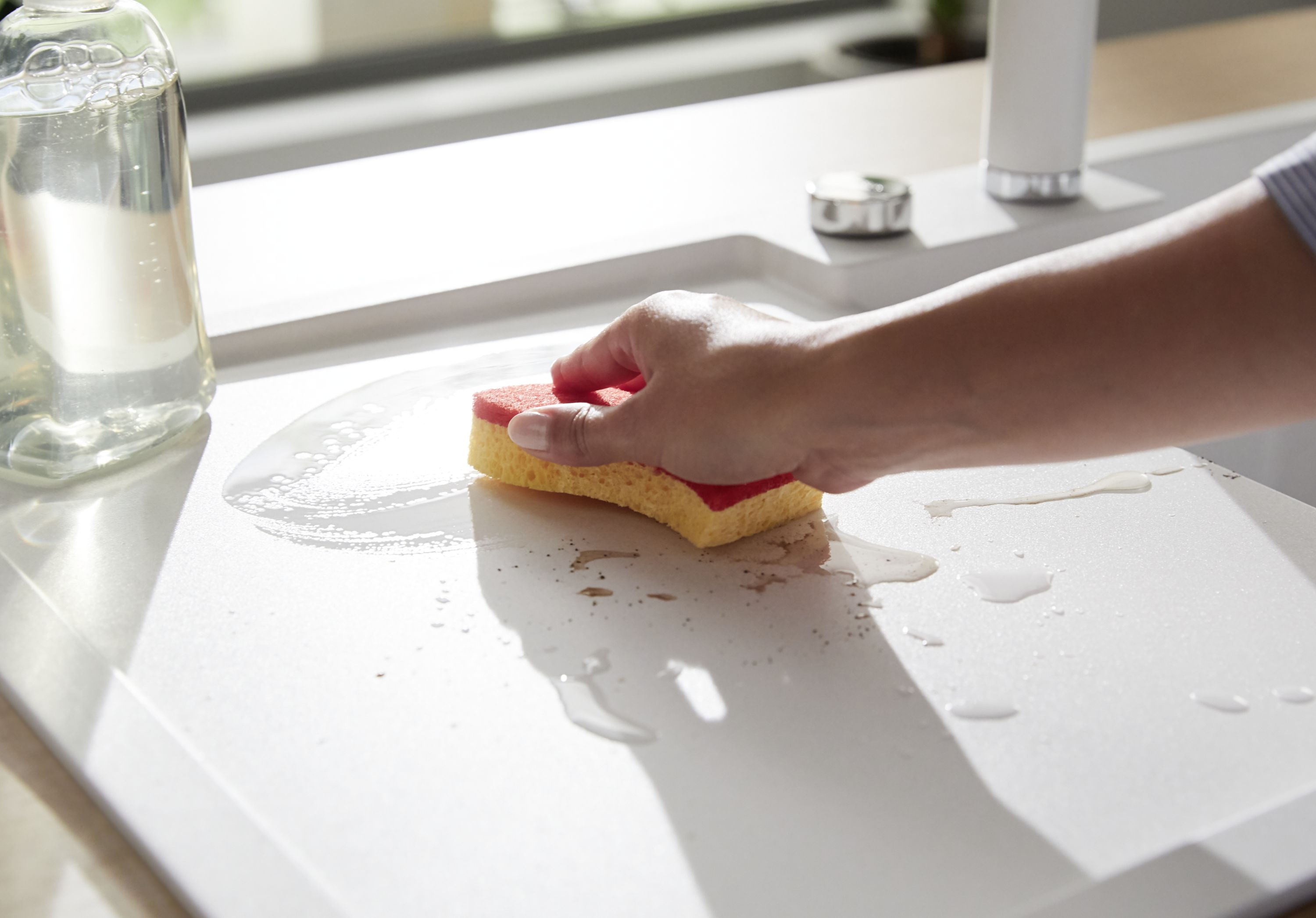 Washing up a ceramic sink with a sponge
