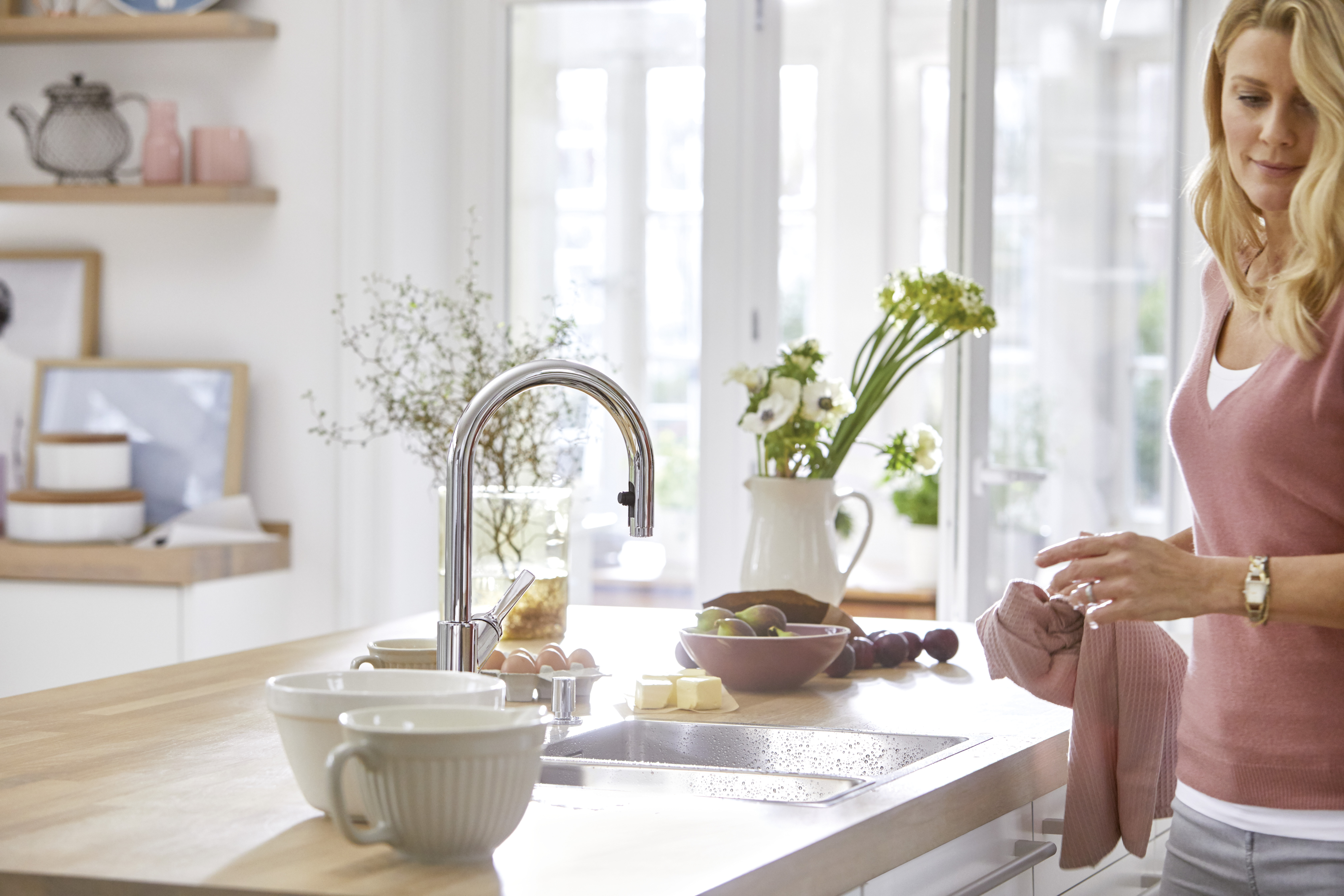 a woman standing in front of a BLANCO sink