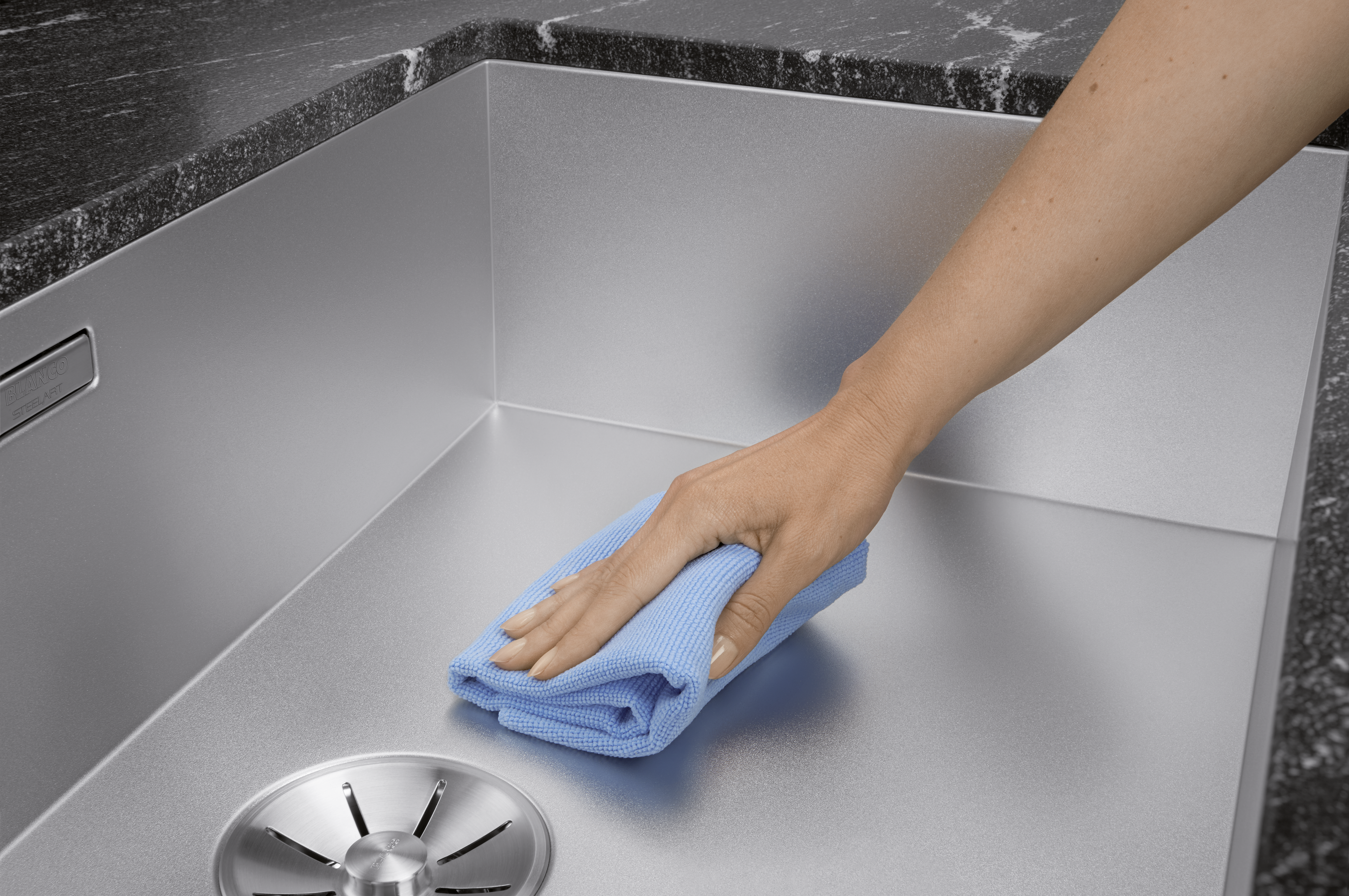 A sink made of Durinox is cleaned with a microfiber cloth