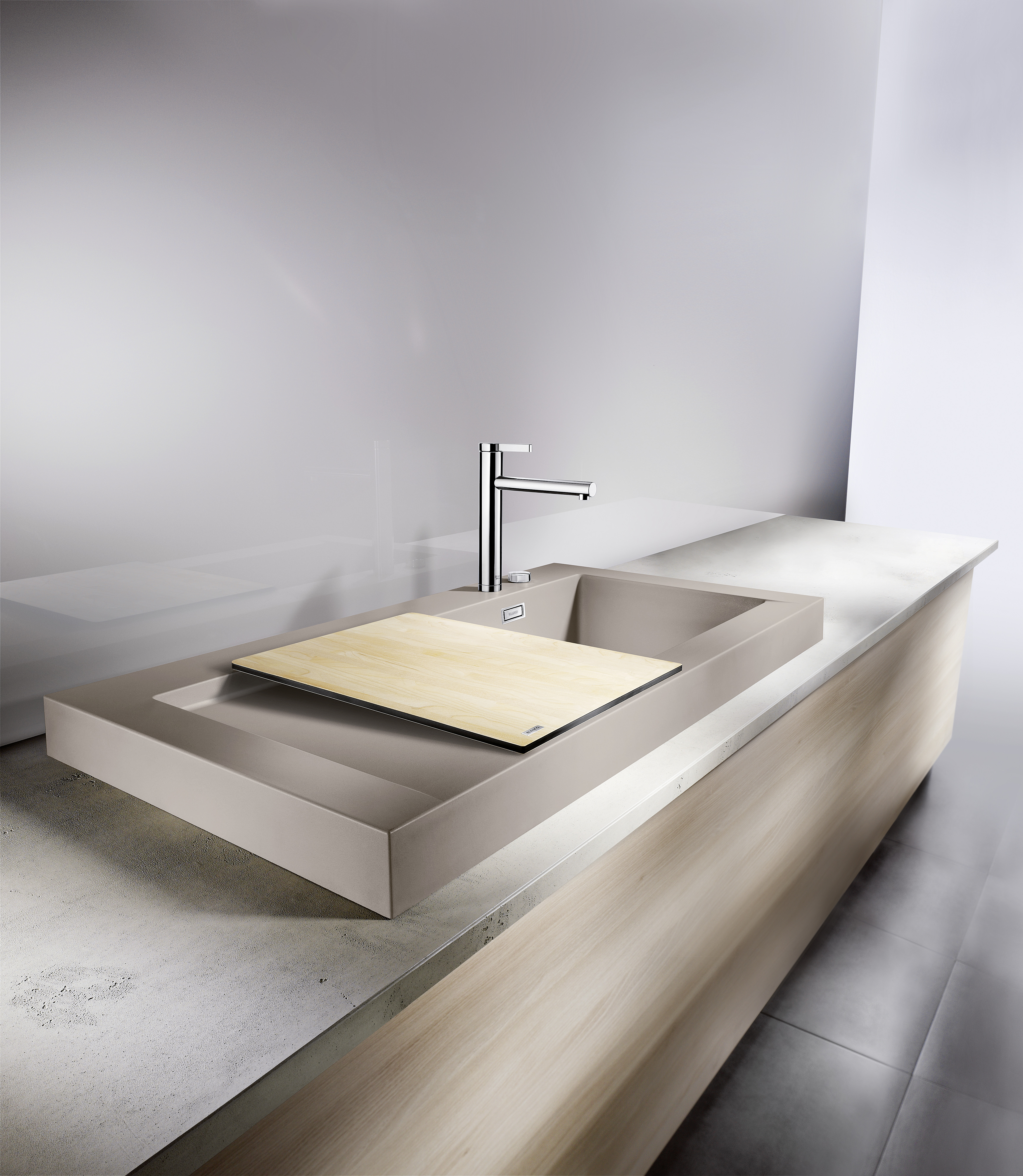 A Concrete sink in grey with a cutting board