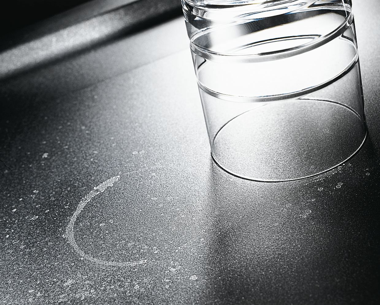 A dark silgranite sink with limescale