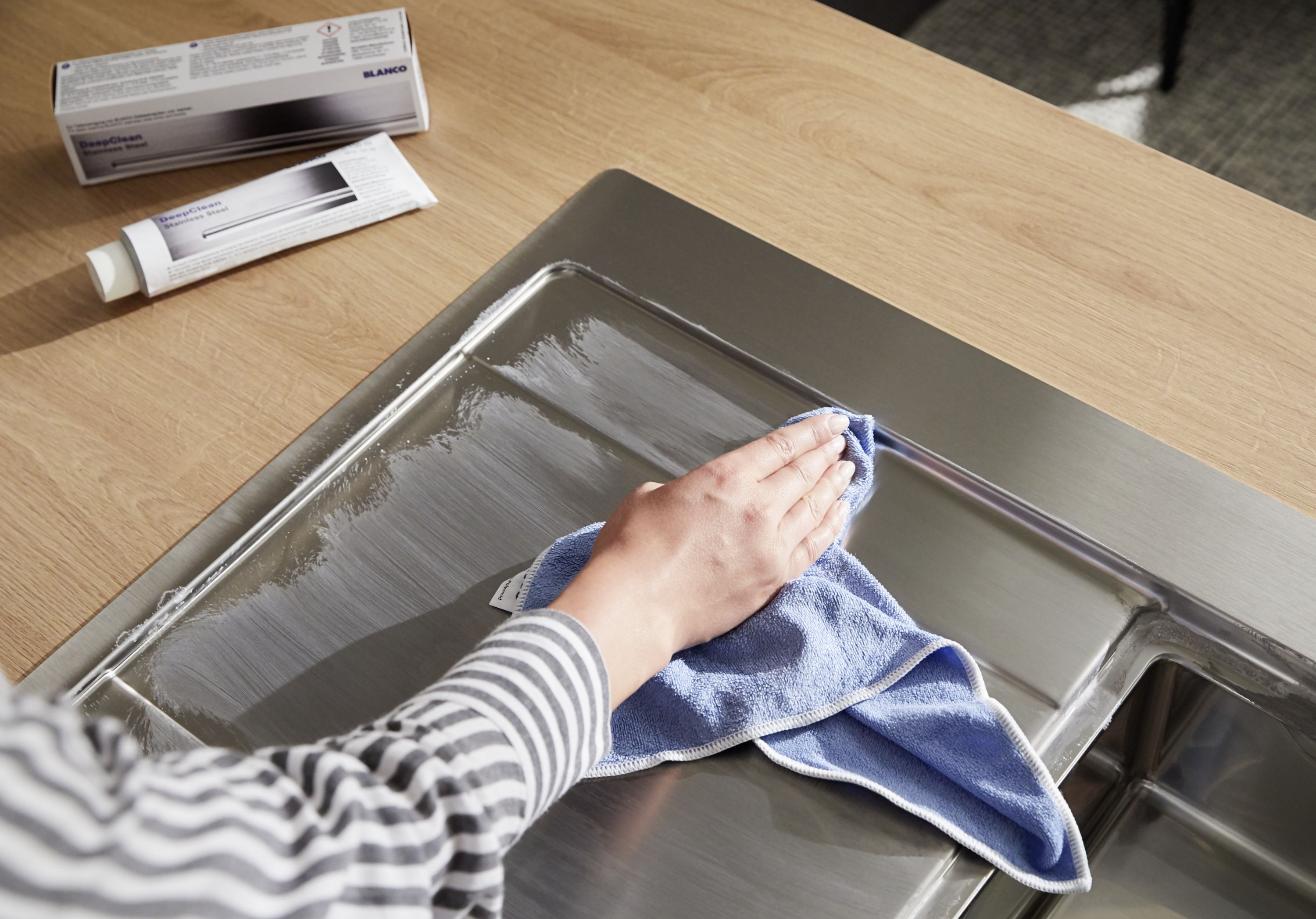 Draining surface of a BLANCO stainless steel sink is cleaned with BLANCO DeepClean Stainless Steel. 