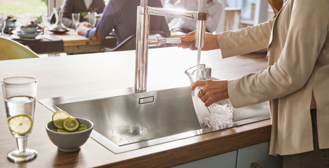 A woman fills a vessel with water